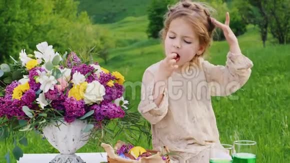 一个穿着漂亮裙子的小女孩坐在一张装饰着鲜花的桌子上吃着一根巧克力手指圣帕特里克节视频的预览图