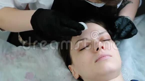 美容师用棉垫摩擦病人眼睑肉毒杆菌和睫毛层压美容治疗视频的预览图
