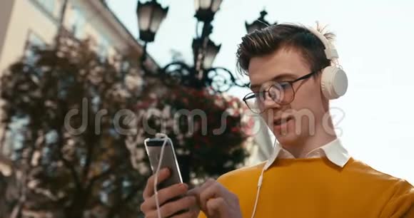 青年与科技一个金发眼镜和雀斑的年轻帅哥在手机上聊天视频的预览图