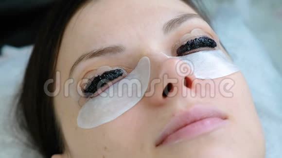美容治疗特写女人睫毛上有油漆的脸肉毒杆菌和复膜睫毛上景视频的预览图