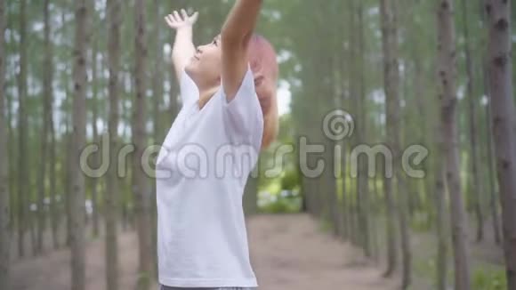 健康美丽的年轻亚洲运动员穿着运动服装双腿发暖手臂准备在森林里奔跑视频的预览图