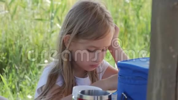 早餐小女孩在野餐时吃户外产品儿童健康食品视频的预览图