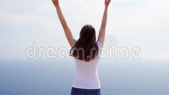 阳光明媚的一天女人在悬崖上与蔚蓝的大海欢快地跳跃免费女性舞蹈视频的预览图