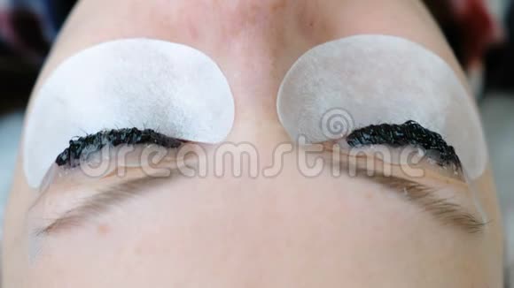 美容治疗女人脸上画着睫毛的特写镜头肉毒杆菌和层压睫毛视频的预览图