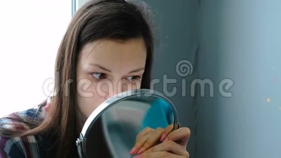 女人在注射肉毒杆菌和睫毛后照镜子视频的预览图