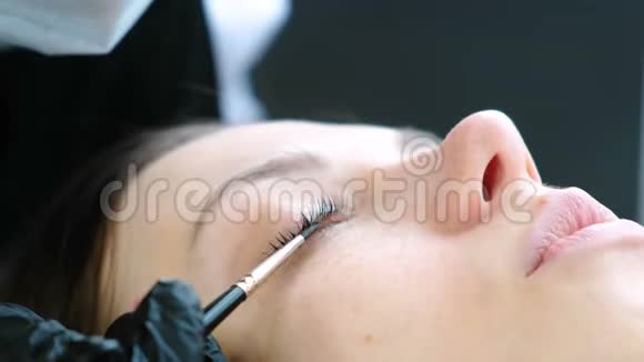 美容师用刷子擦客户睫毛肉毒杆菌和睫毛层压闭上眼睛视频的预览图