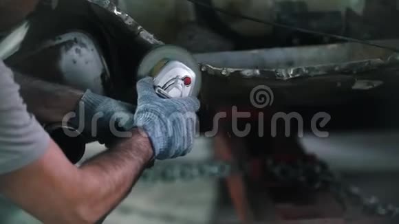 戴眼镜的工人把汽车后部的切口磨碎汽车修理服务飞舞的火花视频的预览图