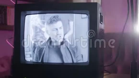 在房间里闪烁着复古电视机播放年轻的男歌手视频的预览图