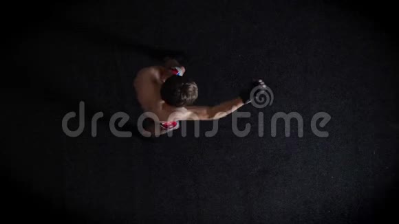 年轻的白种人无胸拳击手做热身击球拳击俯视黑色背景50英尺视频的预览图