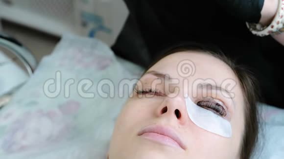 美容师用刷子从客户的眼睛中去除油漆肉毒杆菌和睫毛层压视频的预览图