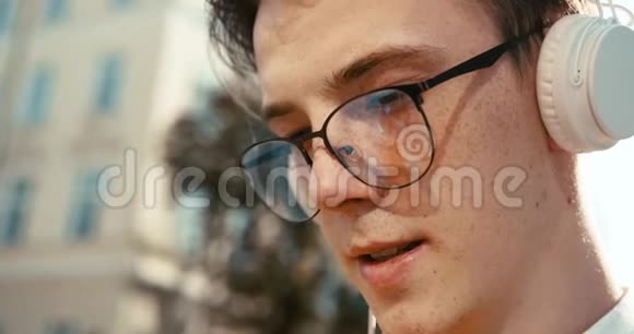 这位戴着眼镜脸上长着雀斑的年轻金发少年的特写镜头正通过视频的预览图