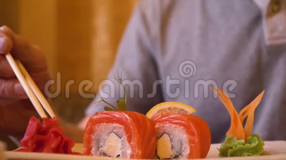 男性在吃寿司卷时用木筷拿红姜视频的预览图