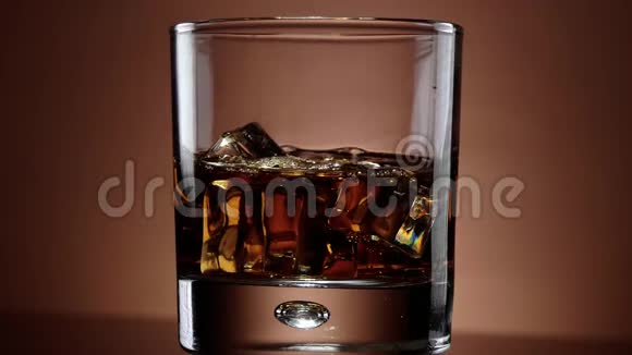 一杯威士忌在冰上近距离慢镜头视频的预览图