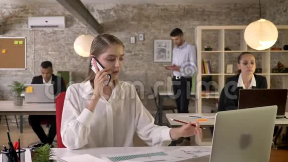 年轻漂亮的商务女性正在办公室打电话人们正在与技术工作理念建立联系视频的预览图
