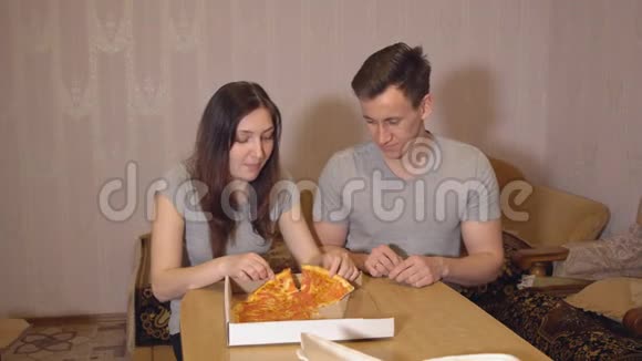 布鲁内特女士和男人在家吃披萨视频的预览图
