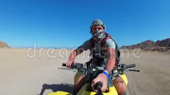 人类正在埃及沙漠骑着一辆四驱车在一个动作镜头上自射视频的预览图
