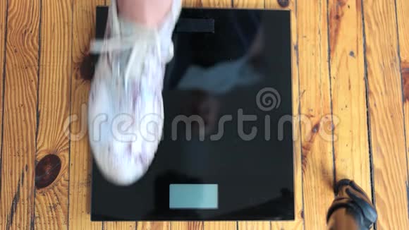 女性的脚站在体重秤上视频的预览图