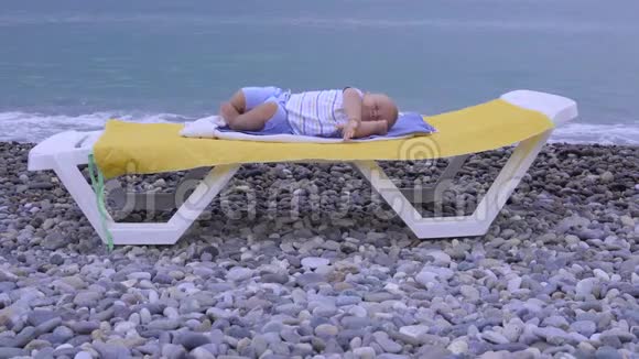 婴儿睡在海滩上视频的预览图