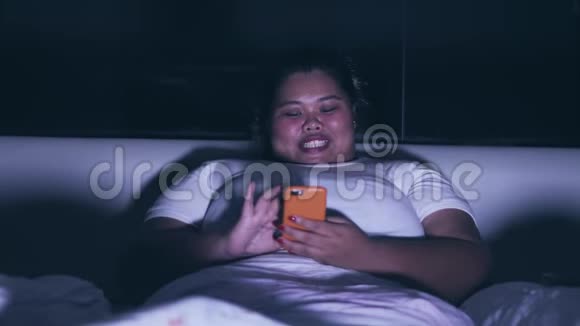超重女性夜间使用手机视频的预览图