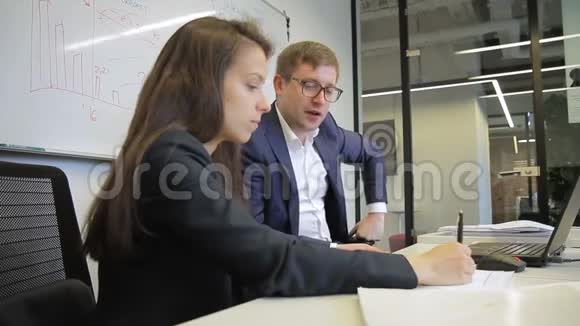 男人和女人在现代办公室做笔记时说话视频的预览图