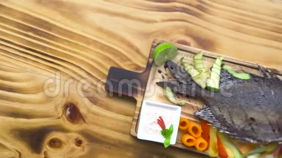 烤鱼和蔬菜装饰在烧烤餐厅食物成分蔬菜和香料烤鱼视频的预览图
