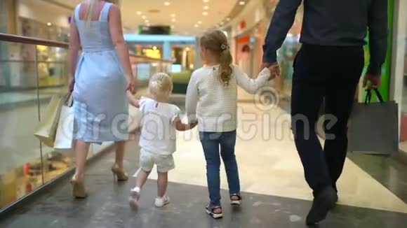 快乐的四口之家在购物在商场里的家人孩子们在购物中心和父母在一起家庭购物在大商店二视频的预览图