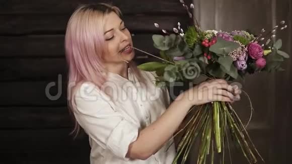 一位专业的花匠用一根细绳把花束的大茎收紧手里握着花束视频的预览图