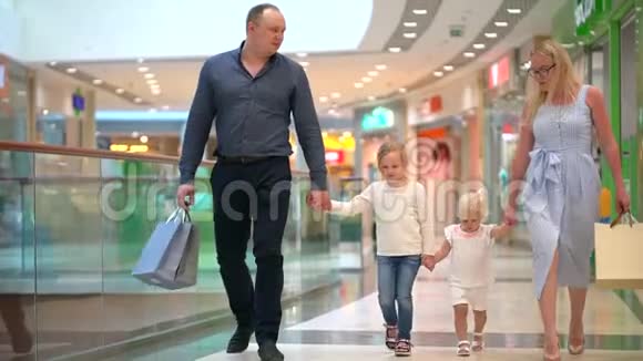 快乐的四口之家在购物在商场里的家人孩子们在购物中心和父母在一起家庭购物在大商店二视频的预览图