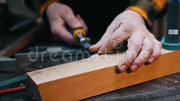 木工行业木工用凿子切割木块上的凹槽视频的预览图