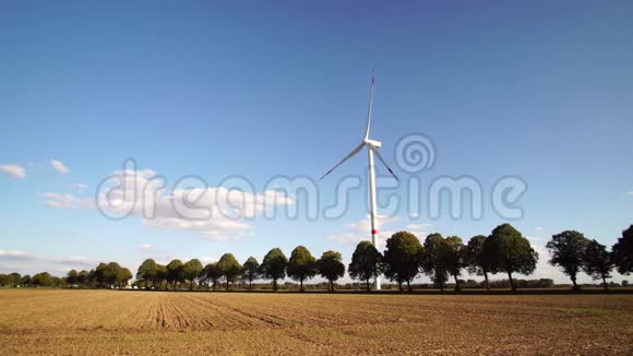 晴天在乡村公路旁的风力涡轮机视频的预览图