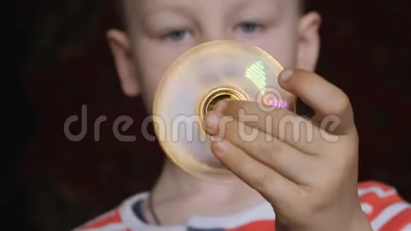 旋转玩具旋转器在一个金发男孩的手中视频的预览图