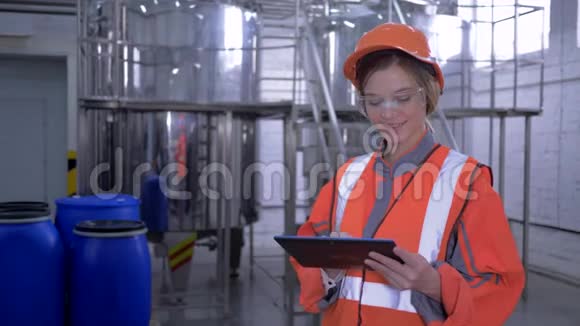 工厂女强人工厂女工人进入头盔整体数字平板电脑制作视频的预览图