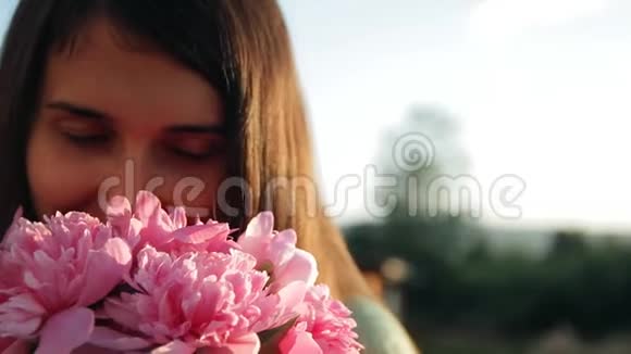 一个年轻美丽的女人带着一束牡丹的肖像的慢镜头视频的预览图