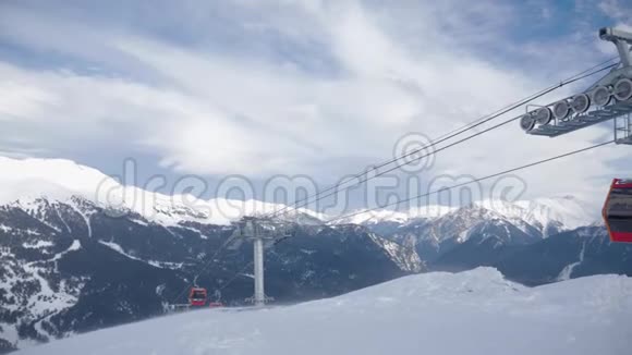 冬天的全景滑雪电梯和雪覆盖的山在一个阳光明媚的日子山脉滑雪电梯在行动视频的预览图