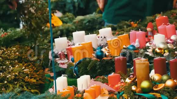 许多不同的五彩蜡烛作为圣诞节和新年的装饰被冬青的树枝包围着视频的预览图