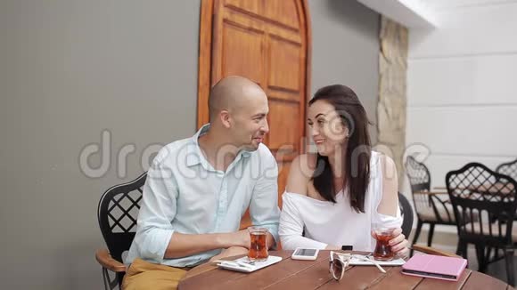 男人和女人在舒适的咖啡馆里喝茶聊天视频的预览图