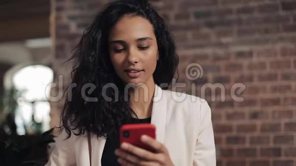 年轻的商务女性在咖啡馆喝茶并使用手机进行社交网络和电子邮件晚餐和网络视频的预览图