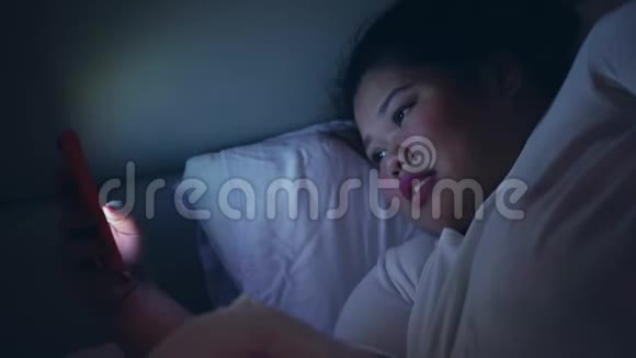 夜间使用智能手机的肥胖妇女视频的预览图