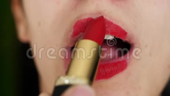 美丽的女孩的肖像她用鲜红的口红巧妙地描绘嘴唇视频的预览图