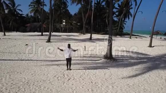 空中非洲男人在海滩上的棕榈树林里跳舞视频的预览图
