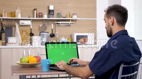 厨房里的年轻人在电脑键盘上打字视频的预览图