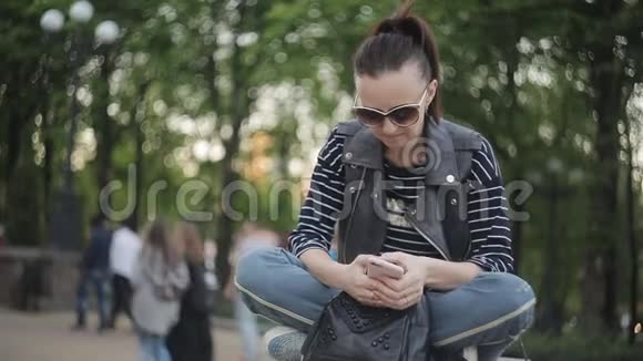 在公共公园用手机的女人视频的预览图