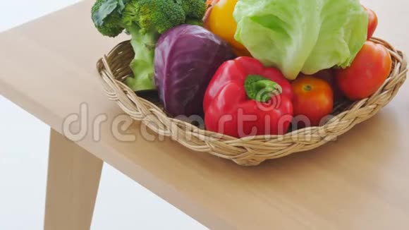 将混合新鲜蔬菜和水果放在木桌上准备做饭手提菜篮子视频的预览图