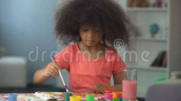 可爱的非裔美国女孩画一幅画微笑着进入相机童年视频的预览图