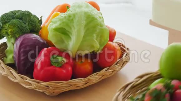 将混合新鲜蔬菜和水果放在木桌上准备做饭手提菜篮子视频的预览图