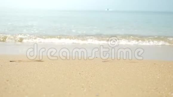 金色的沙滩白色的海沫和蓝色的天空带着沙滩和热带的海浪在远处加速视频的预览图