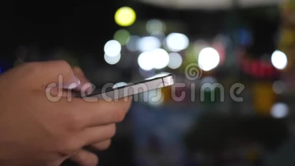 在城市购物街搜索社交网络上儿童夜间使用智能手机的特写镜头视频的预览图