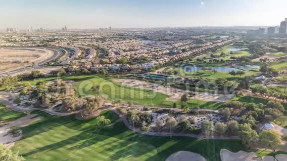阿拉伯联合酋长国迪拜日落前的高尔夫球场和朱美拉湖摩天大楼视频的预览图