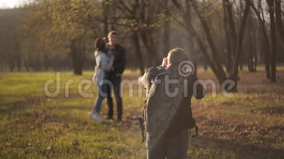 专业摄影师在公园里拍摄年轻可爱的情侣视频的预览图