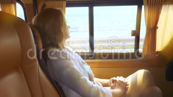 女人望着窗外躺在一辆现代汽车舒适的后座上视频的预览图